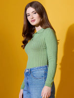 Woman in a 98degreenorth Pear Collar Neck Sweater and blue jeans stands against a yellow background.