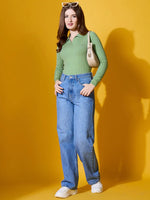 Woman wears 98degreenorth Pear Collar Neck Sweater, blue jeans, sunglasses & sneakers; poses with beige handbag on yellow.