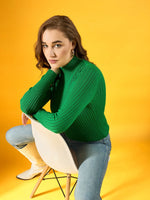 Woman wears 98degreenorth green ribbed high neck sweater and jeans, seated on a chair against a yellow background.