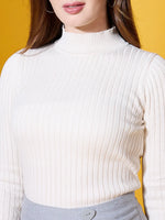 Woman in 98degreenorth Off-White Ribbed High Neck Sweater and gray skirt stands against a yellow background.
