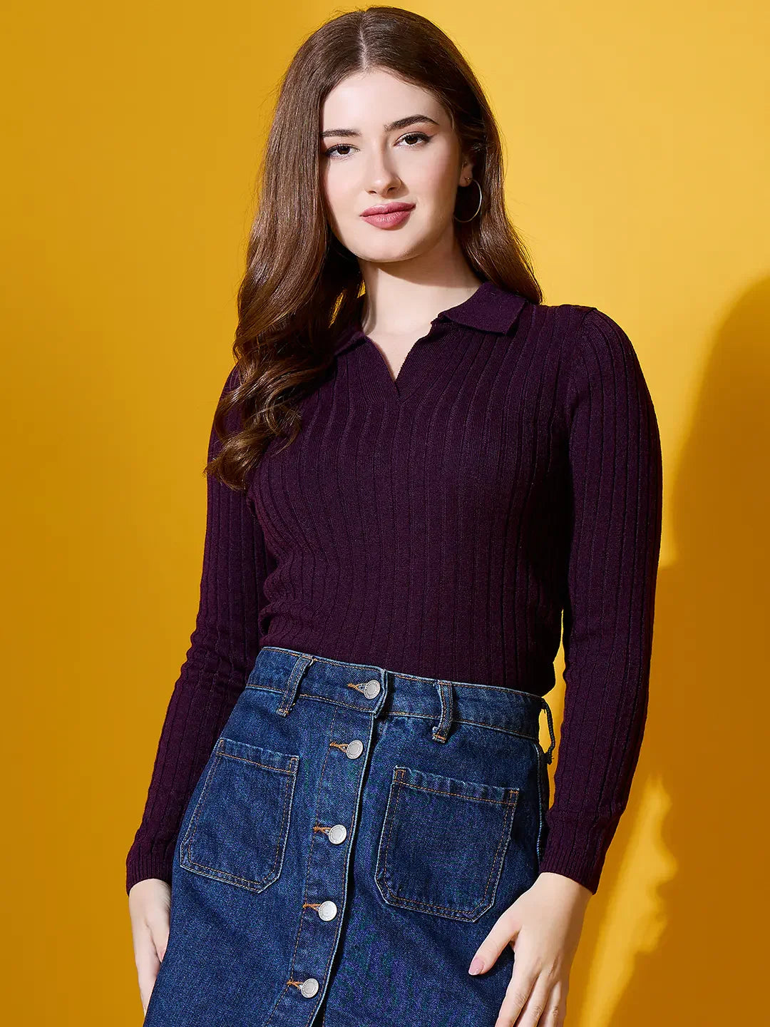 A woman models the 98degreenorth Rosewood Collar Ribbed Sweater, a chic slim-fit winter knit, against a yellow backdrop.