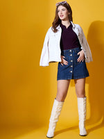 Woman in 98degreenorth Rosewood Collar Neck Ribbed Sweater, styled with a white jacket, denim skirt, and knee-high boots.