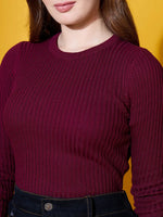 Woman in a 98degreenorth Rosewood Round Neck Ribbed Sweater, styled with high-waisted jeans against a yellow background.
