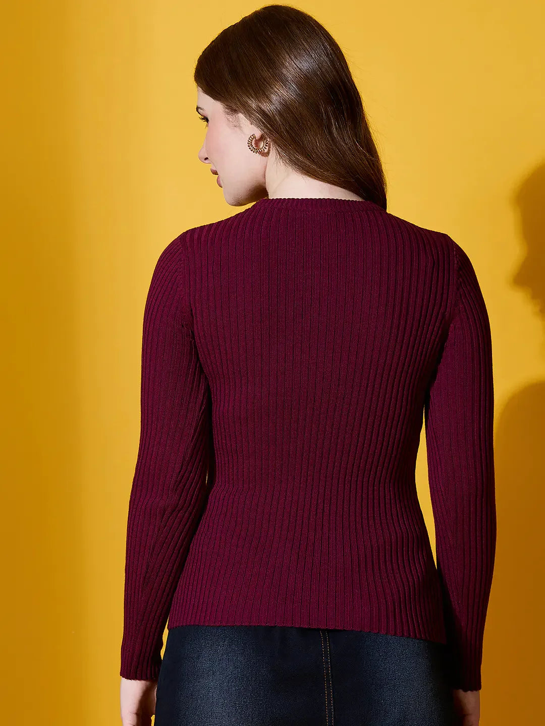 Woman in 98degreenorth Rosewood Round Neck Ribbed Sweater, photographed from the back against a yellow background.