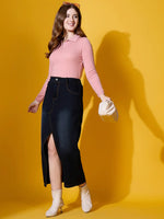 A woman wears the 98degreenorth salmon ribbed collar neck sweater, paired with a denim skirt and white boots.