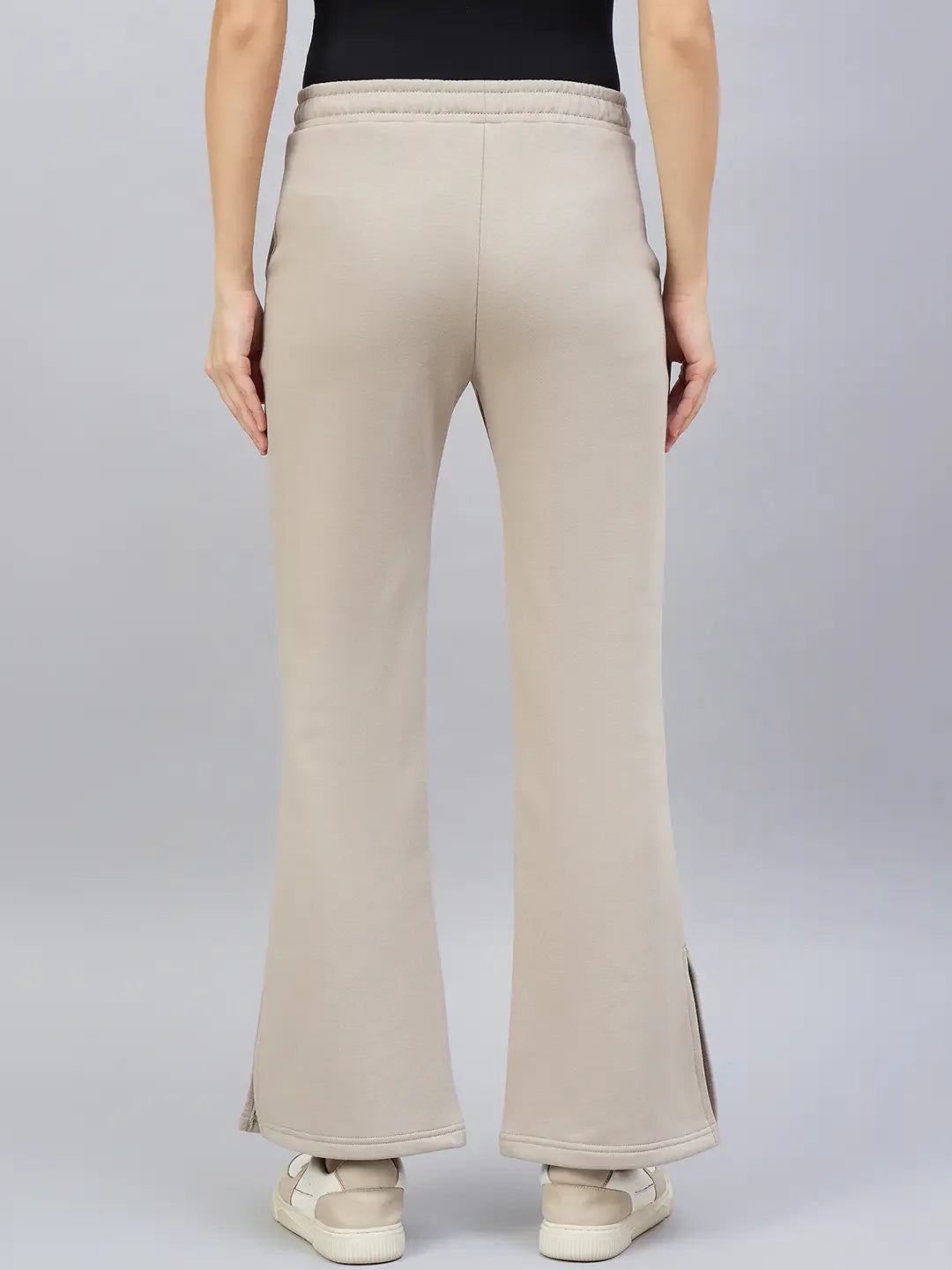 A person wears 98degreenorth Women’s Almond Flared Bootcut Sweatpants with white sandals, shown from the back.
