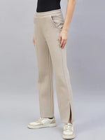 A woman wears 98degreenorth’s almond flared bootcut sweatpants with side slit, paired with white sneakers.