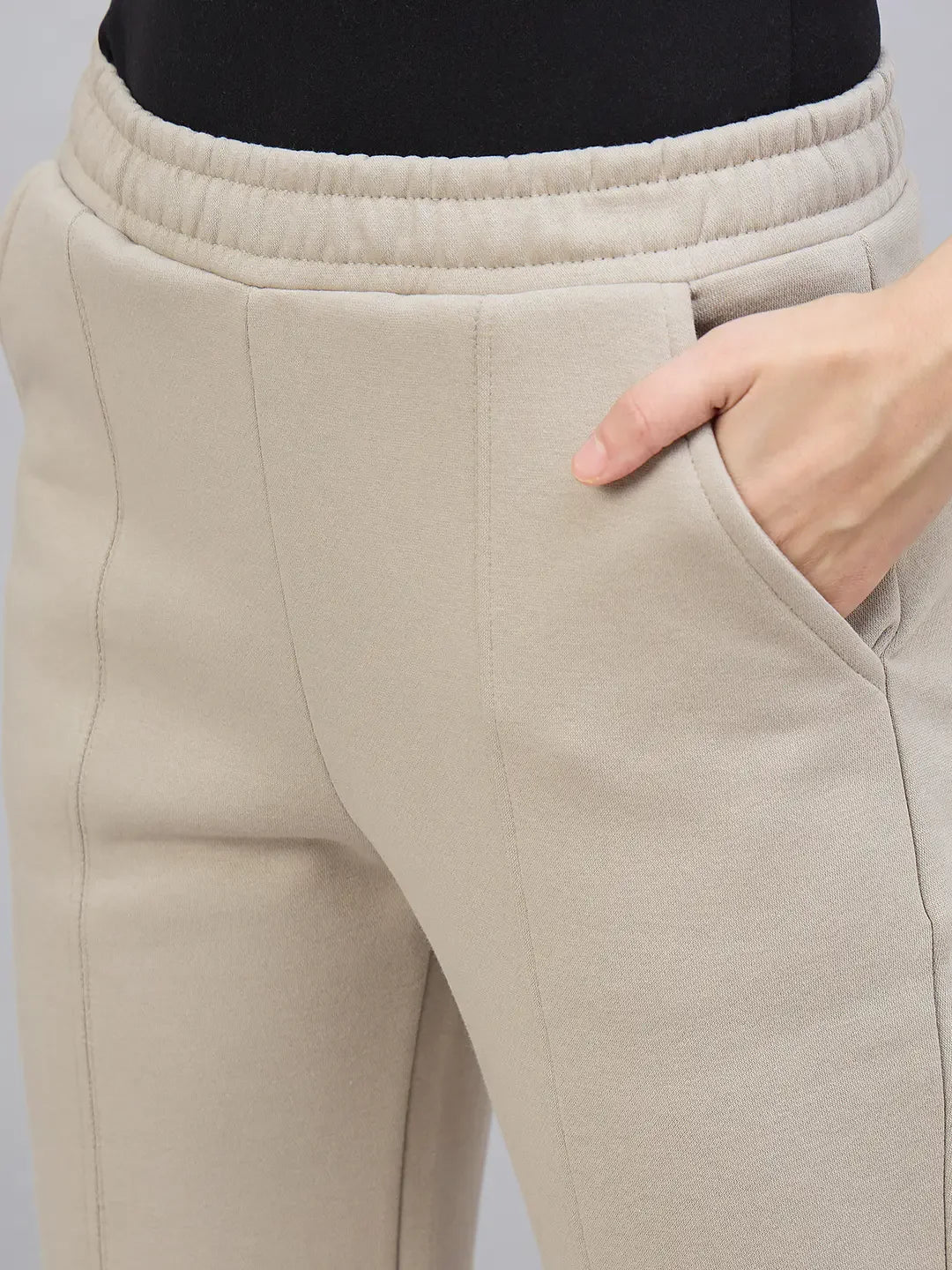 Close-up of a person wearing 98degreenorth Women’s Almond Flared Bootcut Sweatpants with side slit, hand in pocket.