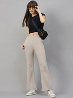 Woman in black crop top, 98degreenorth Almond Fleece Flared Sweatpants, white sneakers, sunglasses, crossbody bag.