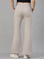 Woman in 98degreenorth high waist Almond Fleece Flared Sweatpants, shown from the back against a gray background.