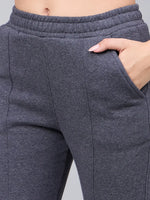 Close-up of a person wearing 98degreenorth Women’s Anthra Fleece Flared Sweatpants with a hand in the pocket.