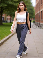 A woman in 98degreenorth Women’s Anthra Fleece Flared Sweatpants walks on campus with a tote and backpack.