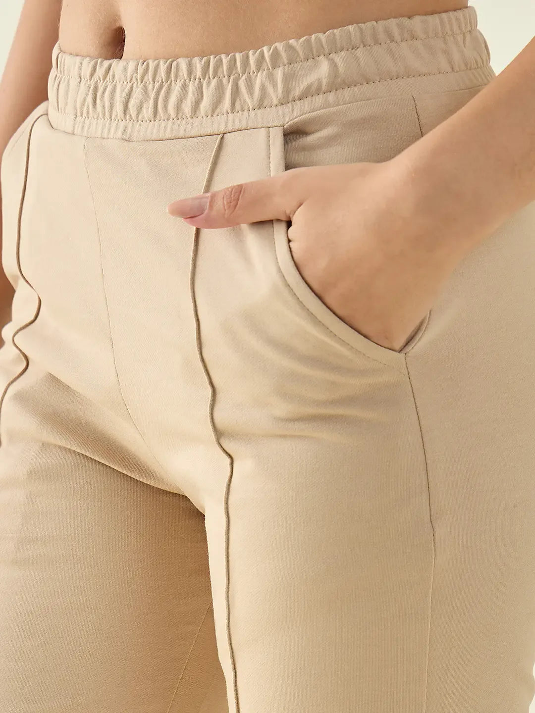Close-up of 98degreenorth Women’s Beige Cotton Stretchable Trackpants with elastic waist and hand in side pocket.