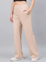 A person wears 98degreenorth Women’s Beige Cotton Stretchable Trackpants, a black crop top, and white sneakers.