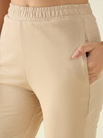 Close-up of a person in 98degreenorth Women’s Beige Flared Fit Bootcut Cotton Stretchable Trousers, hand in pocket.