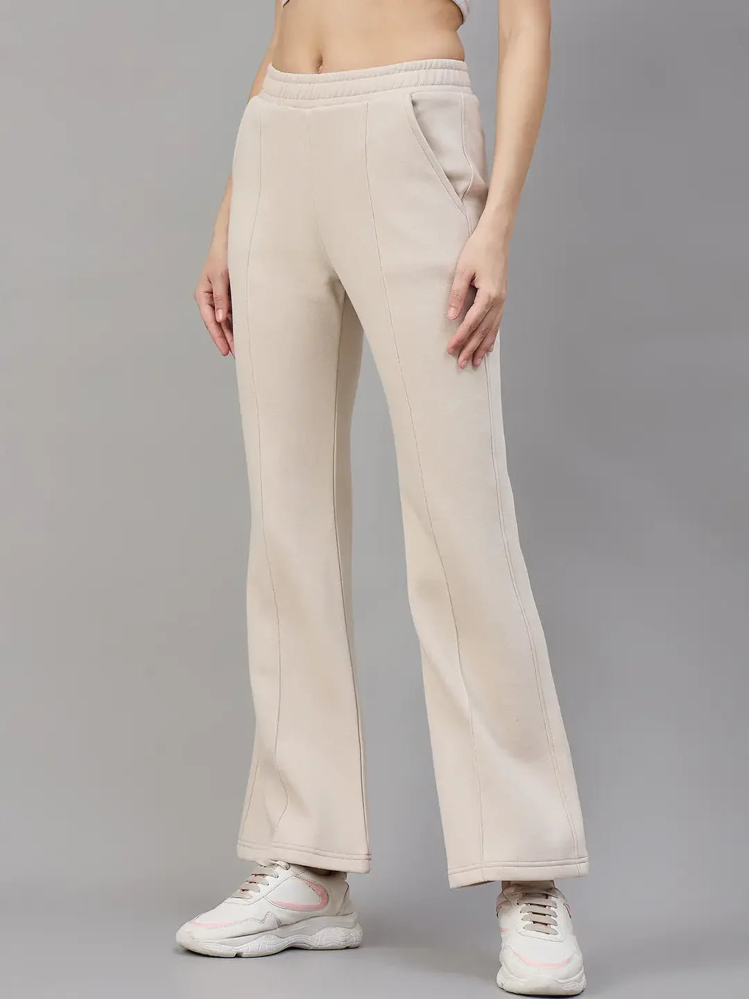 Model wears 98degreenorth Women’s Beige Fleece Flared Lounge Pants, posing against a plain grey background.