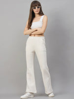 Woman in white crop top and 98degreenorth Beige Fleece Flared Sweatpants, posing against a gray background.