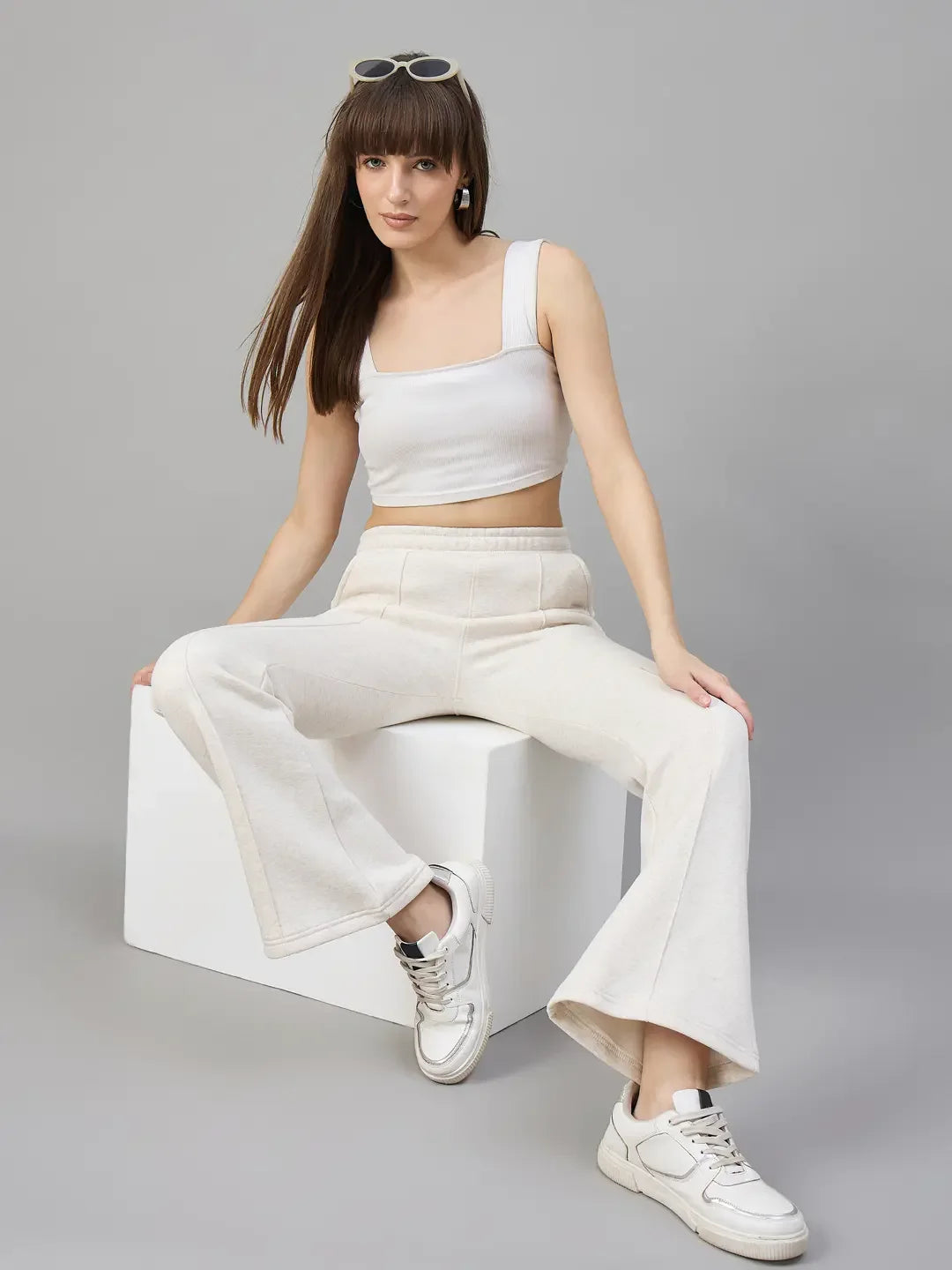 Woman wears 98degreenorth Beige Fleece Flared Sweatpants, showing off minimal streetwear style with fresh white sneakers.