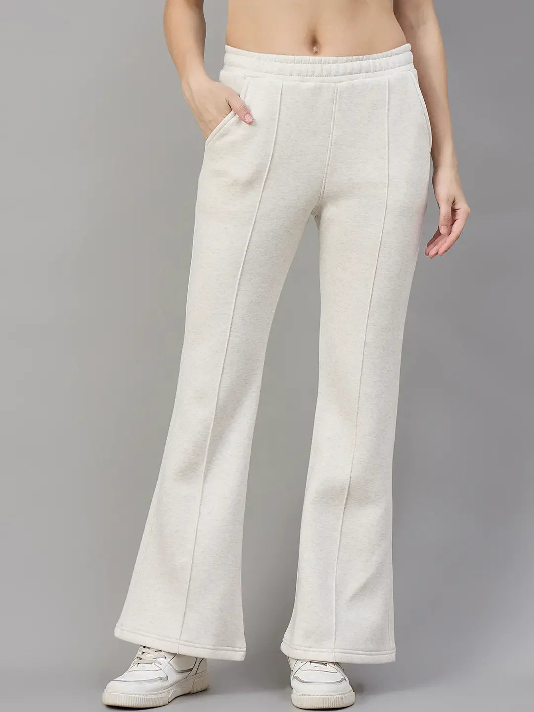 Model wears 98degreenorth Women’s Beige Fleece Flared Sweatpants – Minimal Streetwear Style against a gray background.