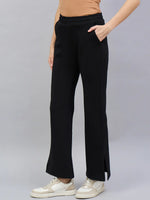 Person wears 98degreenorth Women's Black Bootcut Sweatpants with Side Slit, beige ribbed top, and white sneakers.