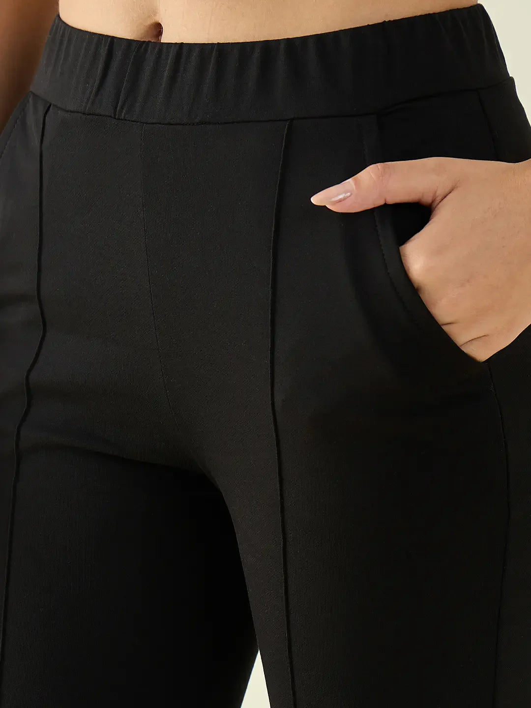 A person in 98degreenorth Women’s Black Flared Bootcut Cotton Stretchable Trousers, highlighting fit and seam details.