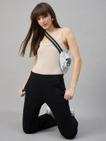 Woman in 98degreenorth Black Fleece Flared Sweatpants – Winter Casual Essential, beige tank top, sneakers, crossbody bag.