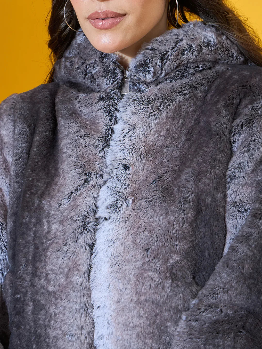 Model in a 98degreenorth Women’s Black Premium Faux Fur Jacket with hood, an urban winter essential.