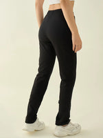 A woman in 98degreenorth Women's Black Cotton Stretchable Trousers stands facing away against a plain background.