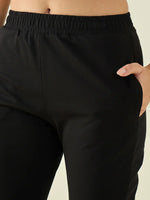 Model wears 98degreenorth Women’s Black Cotton Stretchable Trousers, hand in pocket, waist and upper legs visible.
