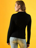 Woman in 98degreenorth Women’s Black Ribbed Collar Neck Sweater and light blue jeans faces a yellow background.