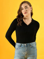 Woman in a 98degreenorth Women’s Black Ribbed Collar Neck Sweater, slim fit, with blue jeans against yellow background.