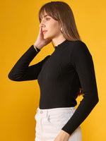 Woman wearing 98degreenorth's black ribbed slim fit turtleneck sweater, posing in front of a yellow background.