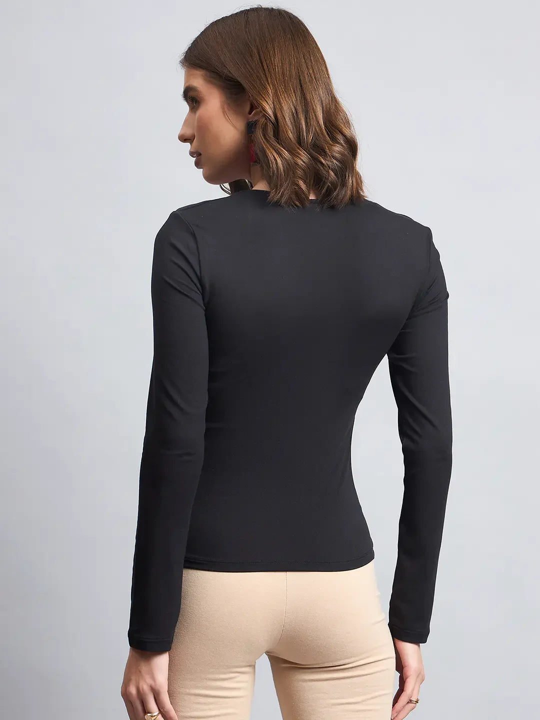 A modern Indian woman wears a 98degreenorth Women’s Black Square Neck Long Sleeve Top with beige pants.