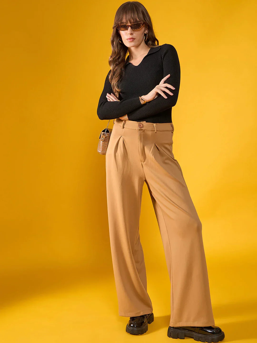 Woman in 98degreenorth’s black slim fit ribbed collar sweater poses confidently against a bright yellow background.