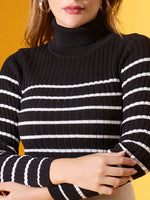 Woman in 98degreenorth Women’s Black Striped Ribbed High Neck Sweater, arms crossed, on a yellow background.