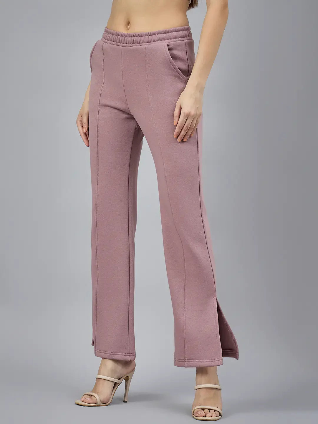 Woman in 98degreenorth Blush Pink Bootcut Sweatpants with side slits, pockets, and beige heeled sandals.
