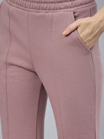 98degreenorth Women’s Blush Pink Bootcut Sweatpants with flared side-slit, hand in pocket on a plain background.