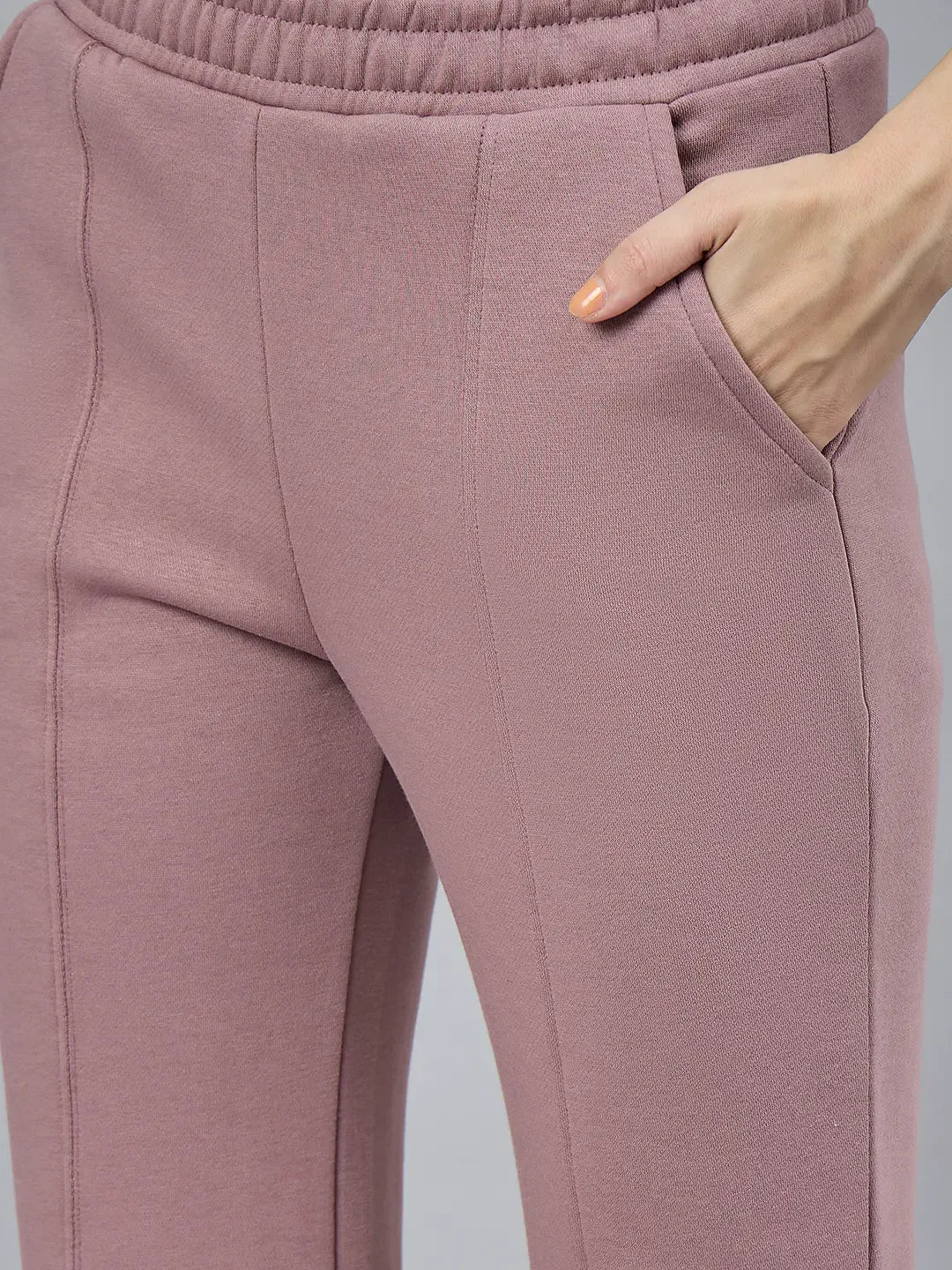 98degreenorth Women’s Blush Pink Bootcut Sweatpants with flared side-slit, hand in pocket on a plain background.