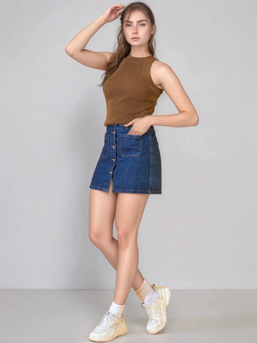 Woman in 98degreenorth Brown Ribbed Halter Neck Sleeveless Knit Top, denim skirt, white socks & sneakers, on plain backdrop.
