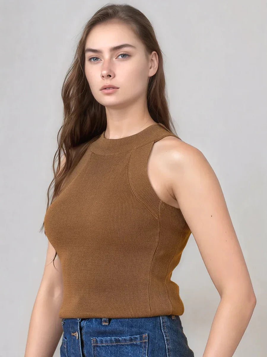 A woman in a 98degreenorth brown ribbed halter neck sleeveless knit top and blue jeans poses against a plain background.