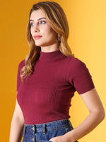 Woman wears 98degreenorth’s burgundy ribbed slim-fit turtle neck sweater, posing against a yellow background.