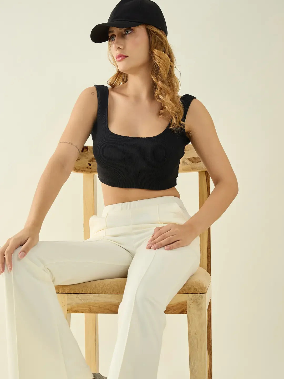 Woman wearing 98degreenorth Women’s Butter Flared Bootcut Cotton Stretchable Trousers sits on a chair.