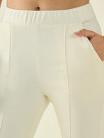 Close-up of a person wearing 98degreenorth Women’s Butter Flared Bootcut Cotton Stretchable Trousers, hands in pockets.