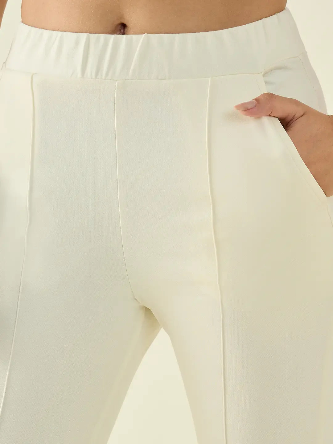 Close-up of a person wearing 98degreenorth Women’s Butter Flared Bootcut Cotton Stretchable Trousers, hands in pockets.