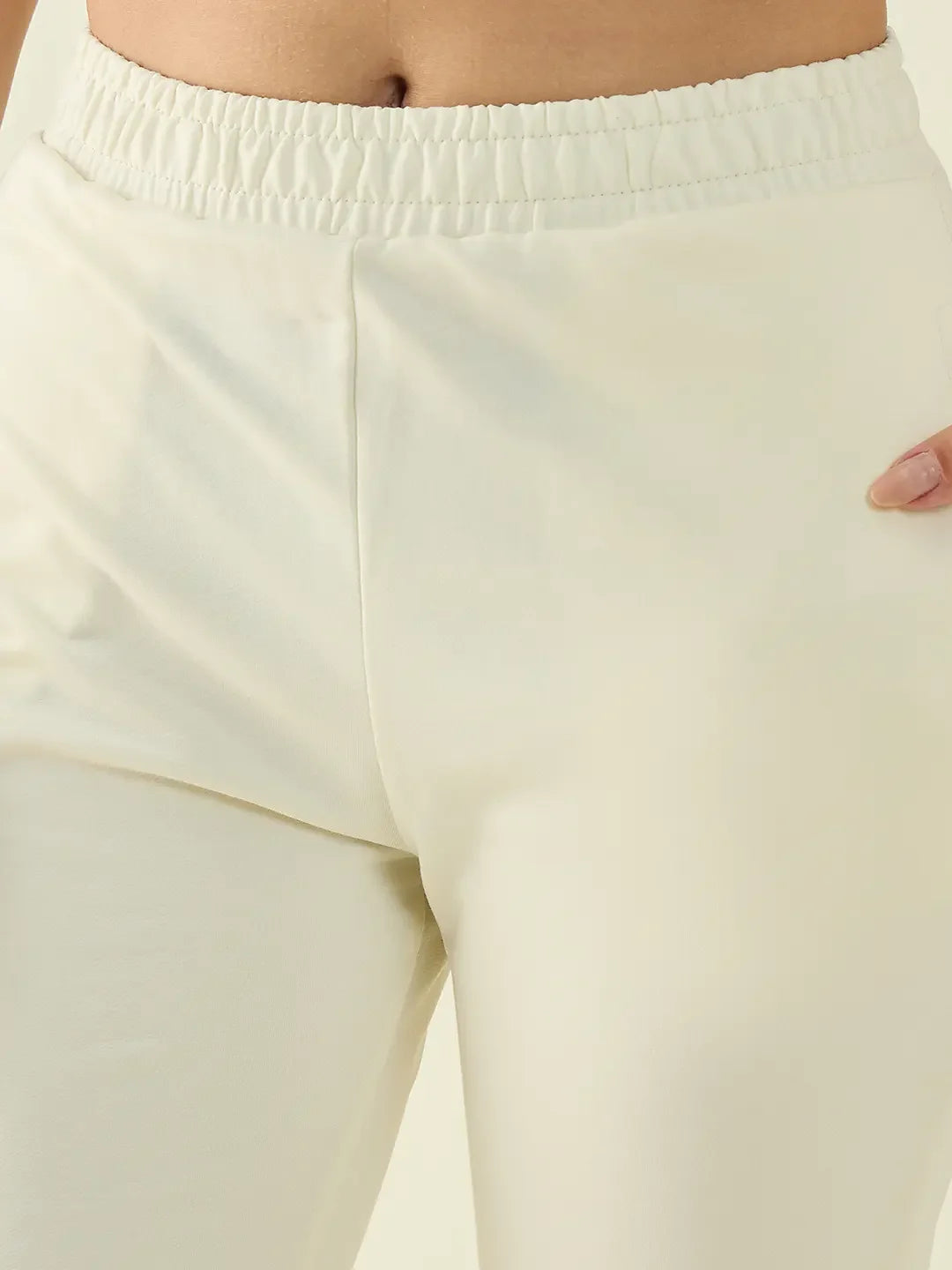 Close-up of a person in 98degreenorth Women’s Butter Flared Fit Bootcut Cotton Stretchable Pastel Trousers.