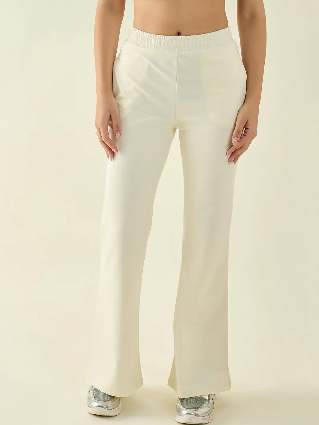 Model in 98degreenorth Chic Pastel Women’s Butter Flared Fit Bootcut Trousers, silver sneakers, on a light backdrop.