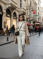 A woman wears 98degreenorth Women’s Butter Flared Fit Bootcut Cotton Stretchable Trousers on a busy city street.