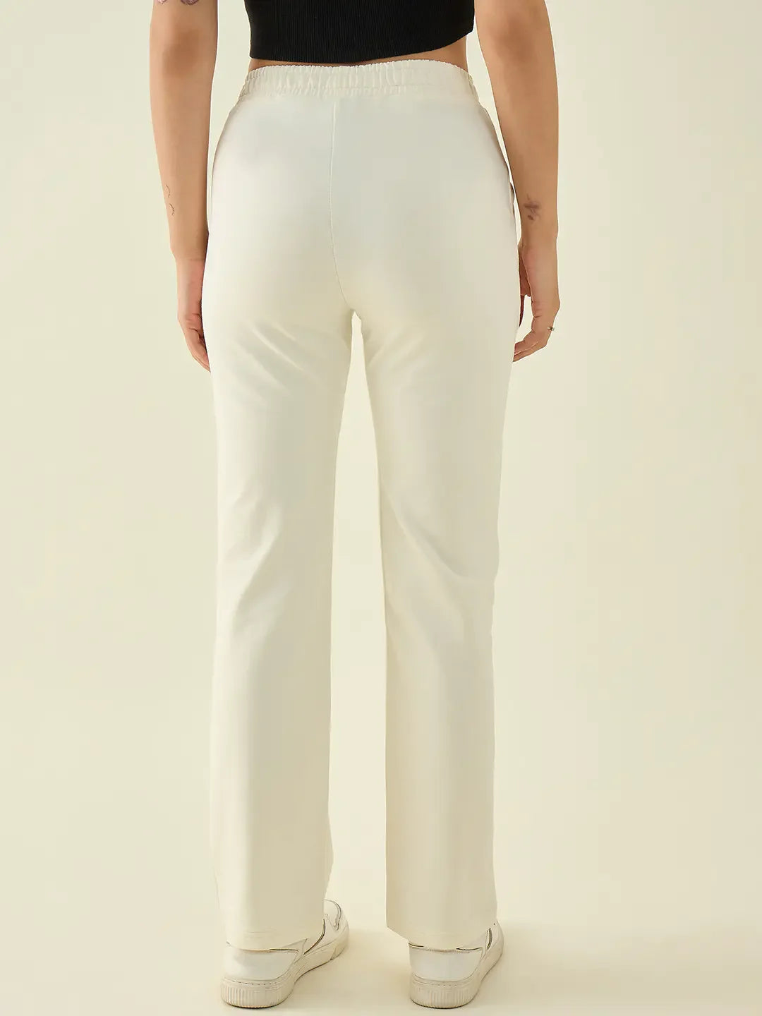 Model in 98degreenorth Women’s Butter Straight Fit Cotton Stretchable Trousers and sneakers, back view.