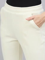 A person in 98degreenorth Women’s Butter Yellow Flared Bootcut Sweatpants, shown from the waist down with a hand in pocket.