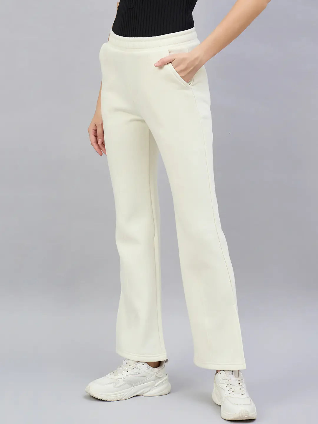 Person wearing 98degreenorth Butter Yellow Flared Bootcut Sweatpants, white sneakers, and a black ribbed top, on gray background.